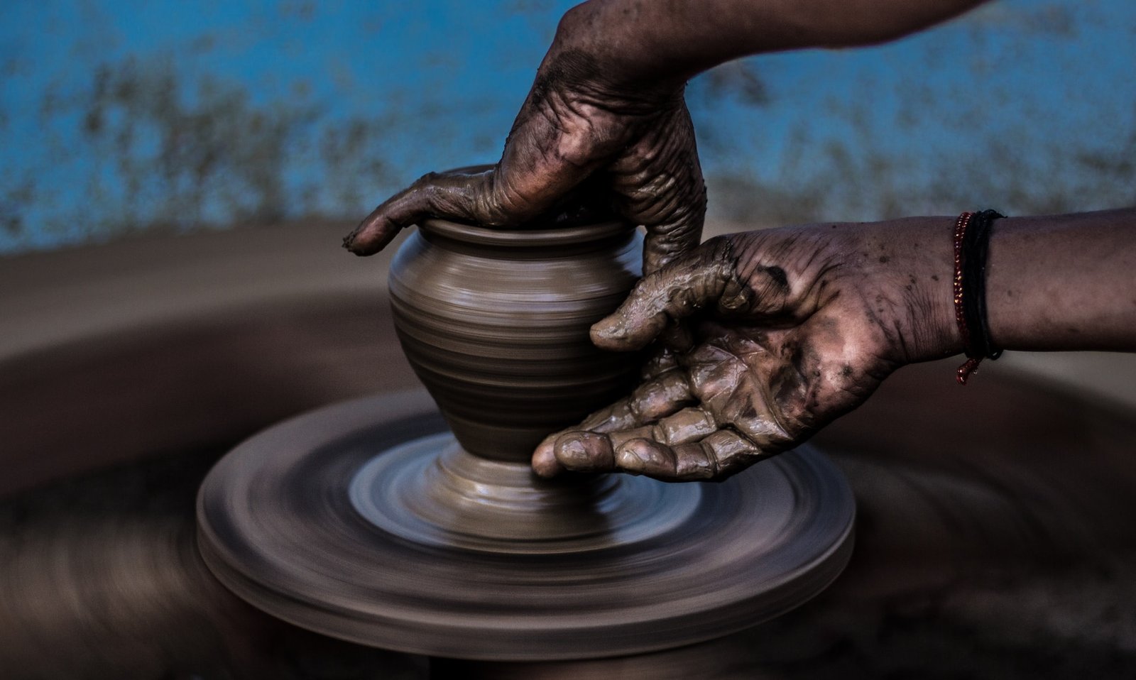 Hands crafting a clay pot